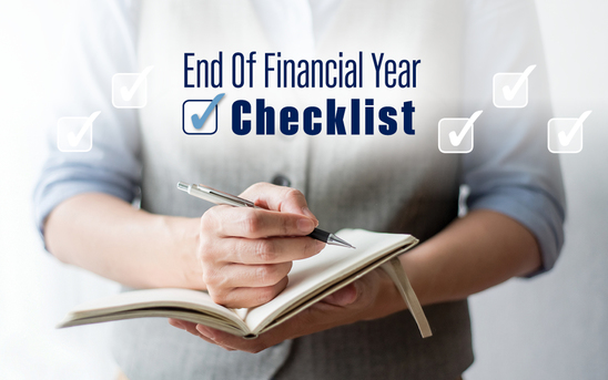 Person writing in notebook with the text 'end of financial year checklist'
